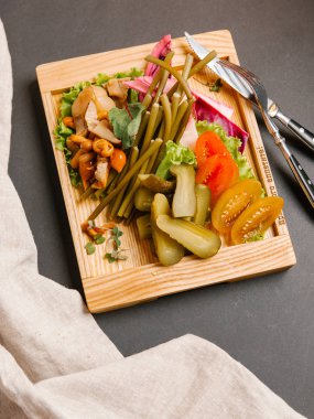 Chaser turşu çeşitleri ile ahşap tepsi üzerinde taze sebze ile servis