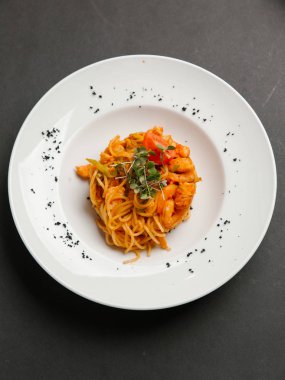  otlar ve beyaz tabakta domates parça ile spagetti karides ile servis