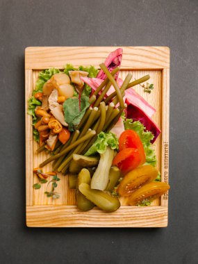 Chaser turşu çeşitleri ile ahşap tepsi üzerinde taze sebze ile servis