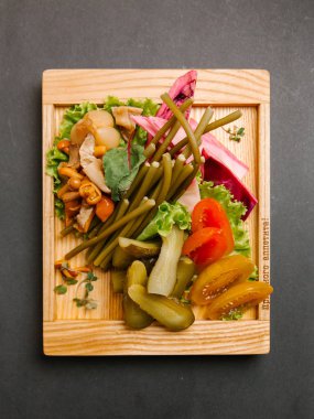 Chaser turşu çeşitleri ile ahşap tepsi üzerinde taze sebze ile servis