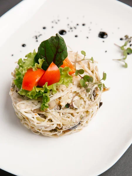 Sebze salata domates parçaları ve marul yaprakları eşliğinde