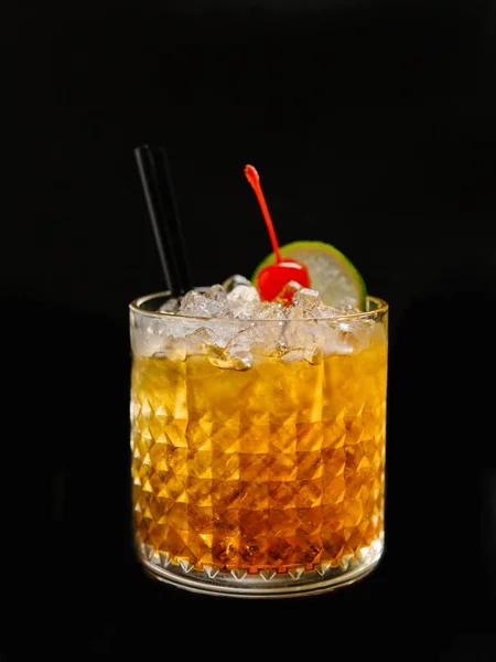 アルコール カクテル多面的なガラスにライム スライス チェリー 氷とストローを添えて — ストック写真