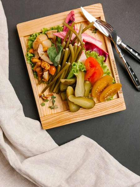 Chaser turşu çeşitleri ile ahşap tepsi üzerinde taze sebze ile servis