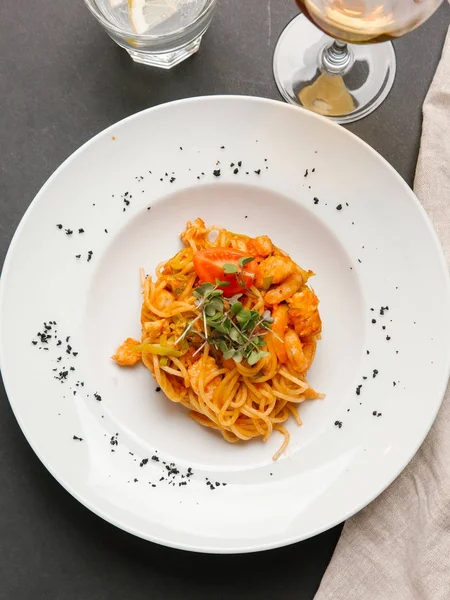 Spaghetti Krewetkami Podawane Ziół Pomidor Kawałek Białym Talerzu — Zdjęcie stockowe