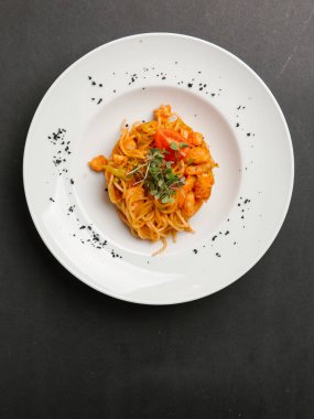  otlar ve beyaz tabakta domates parça ile spagetti karides ile servis