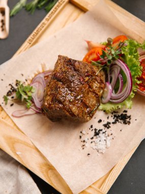 Kaburga eti sebze ve ahşap tepsi üzerinde domates sosu ile