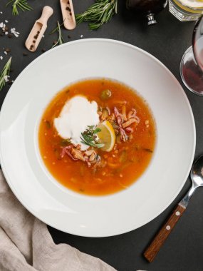 Beyaz tabak içinde limon ve ekşi krema ile servis Solyanka