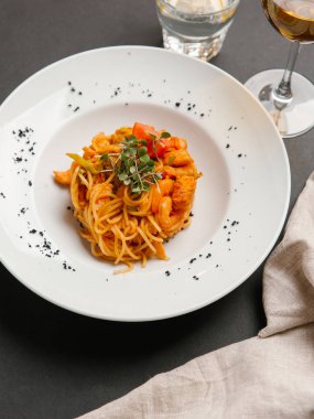 otlar ve beyaz tabakta domates parça ile spagetti karides ile servis