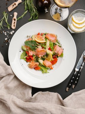 Tuzlanmış somon ve beyaz tabakta sebze salatası