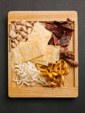 ahşap tepsi üzerinde Chaser Antep fıstığı, kızarmış biftek, patates cipsi ve kuru mürekkep ile hizmet