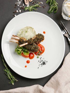 pirzola bitkisel sosu altında beyaz tabakta domates sosu ile servis ezme patates ile