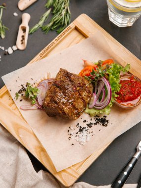 Kaburga eti sebze ve ahşap tepsi üzerinde domates sosu ile