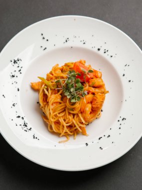  otlar ve beyaz tabakta domates parça ile spagetti karides ile servis