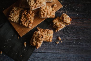 Ahşap doğrama tahtası ve koyu gri peçete üzerinde Görünümü Kapat rendelenmiş pasta servis