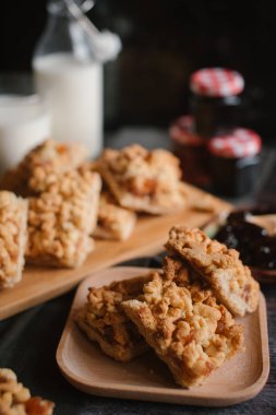 Hizmet üzerinde Ahşap doğrama tahtası içinde elma reçel ile rendelenmiş pasta ve ahşap plaka ile süt ve meyve reçeli