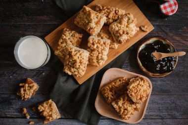 Ahşap doğrama tahtası ve ahşap plaka üzerinde berry reçel ve taze süt ile servis rendelenmiş pastadan görünümü