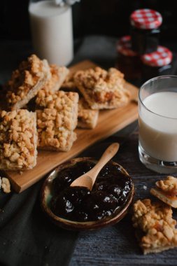 Doğrama kurulu üzerinde süt ve meyve reçeli ile rendelenmiş pasta servis