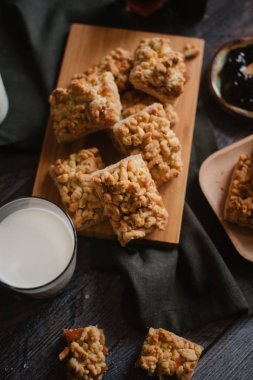 Ahşap doğrama tahtası ve ahşap plaka üzerinde berry reçel ve taze süt ile servis rendelenmiş pastadan görünümü