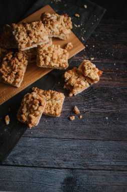 Hizmet üzerinde Ahşap doğrama tahtası ve karanlık peçete içinde elma reçel ile rendelenmiş pastadan Üstten Görünüm