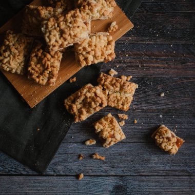Hizmet üzerinde Ahşap doğrama tahtası ve karanlık peçete içinde elma reçel ile rendelenmiş pastadan Üstten Görünüm