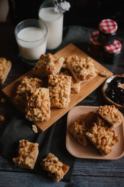 doğrama kurulu koyu gri peçete, reçel ve süt ile woden rendelenmiş pasta servis