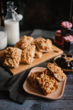 Hizmet üzerinde Ahşap doğrama tahtası içinde elma reçel ile rendelenmiş pasta ve ahşap plaka ile süt ve meyve reçeli