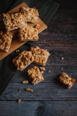 Hizmet üzerinde Ahşap doğrama tahtası ve karanlık peçete içinde elma reçel ile rendelenmiş pastadan Üstten Görünüm