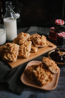 Hizmet üzerinde Ahşap doğrama tahtası içinde elma reçel ile rendelenmiş pasta ve ahşap plaka ile süt ve meyve reçeli