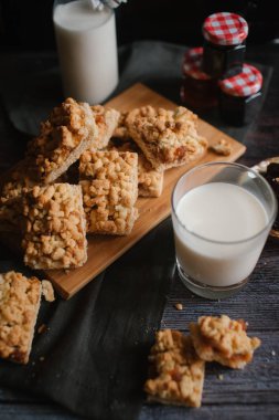 doğrama kurulu koyu gri peçete, reçel ve süt ile woden rendelenmiş pasta servis