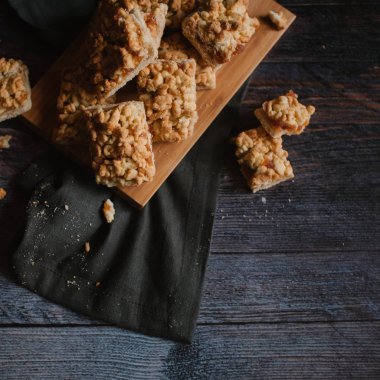 Ahşap doğrama tahtası ve koyu gri peçete üzerinde Görünümü Kapat rendelenmiş pasta servis