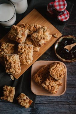 Hizmet üzerinde Ahşap doğrama tahtası içinde elma reçel ile rendelenmiş pasta ve ahşap plaka ile süt ve meyve reçeli