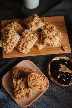 Ahşap doğrama tahtası ve ahşap plaka üzerinde berry reçel ve taze süt ile servis rendelenmiş pastadan görünümü