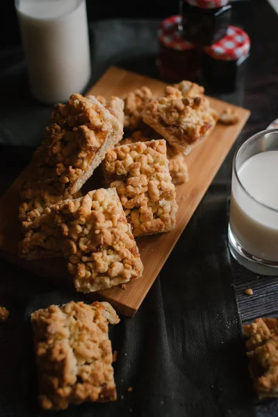 Doğrama kurulu koyu gri peçete, reçel ve süt ile rendelenmiş pastadan Görünümü Kapat woden üzerinde hizmet