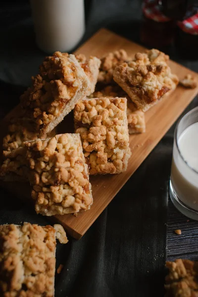 Doğrama kurulu koyu gri peçete, reçel ve süt ile rendelenmiş pastadan Görünümü Kapat woden üzerinde hizmet