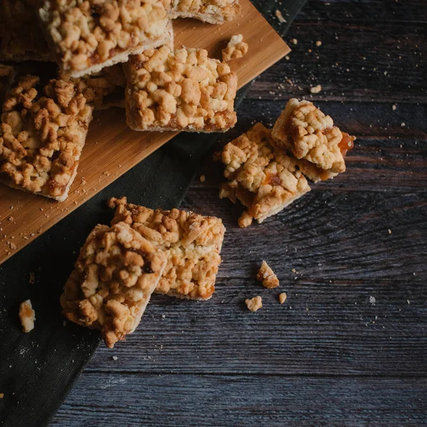 Ahşap doğrama tahtası ve koyu gri peçete üzerinde Görünümü Kapat rendelenmiş pasta servis