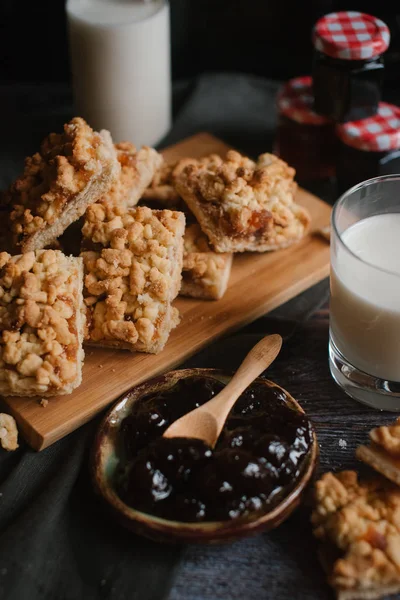 Doğrama kurulu üzerinde süt ve meyve reçeli ile rendelenmiş pasta servis