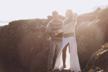 Dağ üzerinde duran ve güneşin tadını çıkarma örme Kazaklar giymiş genç güzel Çift