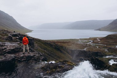 Arkadan görünüş adam şelale duran ve manzara keyfi