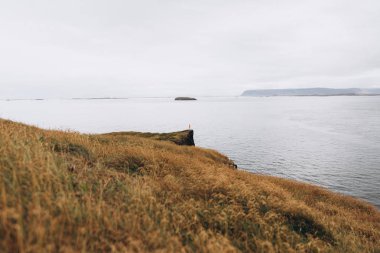 Adam uçurumun kenarında soğuk yağmurlu günde ayakta görünümünü gözlemleyerek