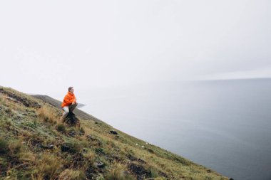 Taş üzerine oturan ve doğal manzarayı Tepesi'nden genç adam 