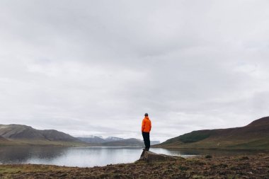 Nehir kenarında duran ve dağlar manzara zevk insanın arkadan görünüş