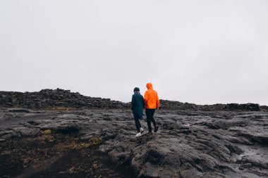 Yağmurlu günde dağlarda yürüyüş genç çiftin arkadan görünüş