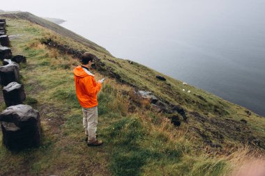 Tepede duran ve doğal manzarayı genç adam