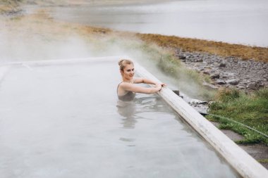 Genç kadın dış ve soğuk yağmurlu günde rahatlatıcı banyo görünümünü