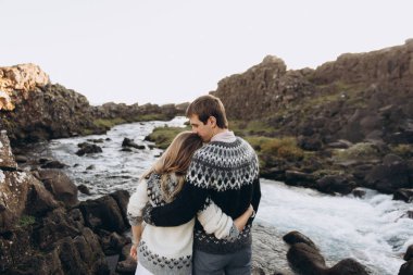 Streamlet arka plan üzerinde sarılma kazak örme sıcak genç çift giymiş