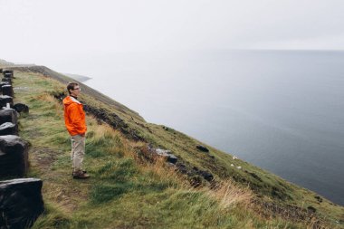 Tepede duran ve doğal manzarayı genç adam