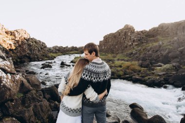 Streamlet arka plan üzerinde sarılma kazak örme sıcak genç çift giymiş