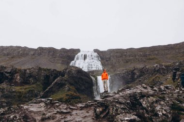Soğuk yağmurlu bir gün zevk şelale ve dağ görünümünde genç adam