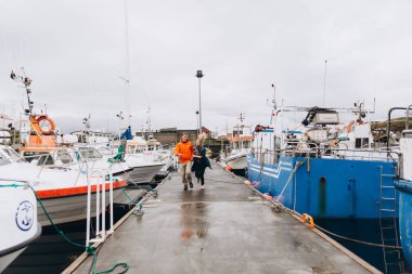 Genç çift yakınındaki yat limanında yürürken atlama