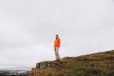 Alt görünümü soğuk yağmurlu günde uçurumun kenarında duran adam